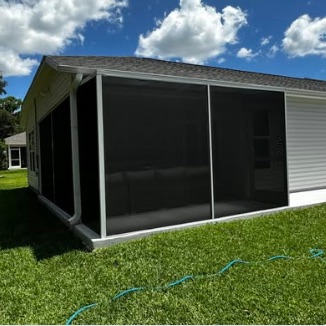 Screened lanai in charcoal mesh running the full length of a single-storey home