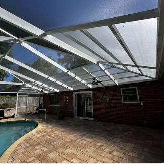 View up at a white screen roof over a pool and paver deck