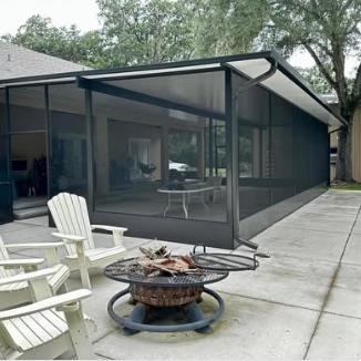 Dark-frame screen enclosure beside a fire pit and Adirondack chairs