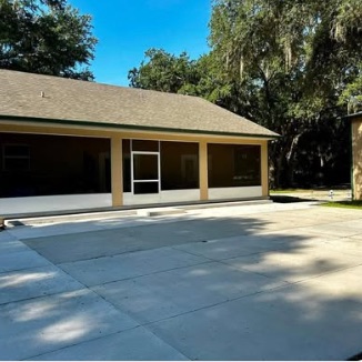 Screened porch under mature oak canopy with Spanish moss